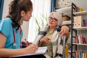 young female doctor doing personal consultation with senior woman in her home