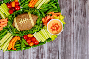 Football meatloaf with fresh vegetable platter and dipping for championship game fan party.