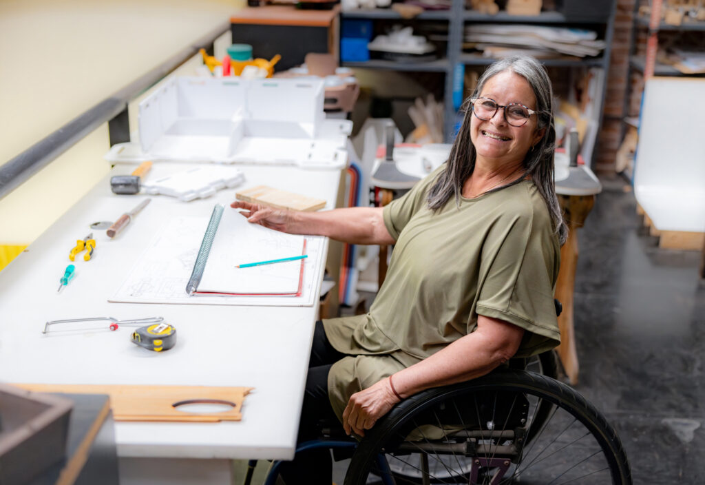 Happy disabled woman working at a furniture factory and looking at the camera smiling -accessibility concepts